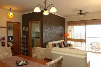 a living room with a couch and a table at Magos Sunrise - Apt with sea view in Caniço