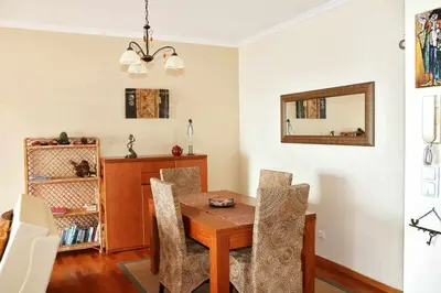 a dining room with a wooden table and chairs at Magos Sunrise - Apt with sea view in Caniço