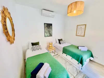 a bedroom with two beds and a mirror at Casa das Amoreiras by YMR in Arco da Calheta