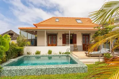 a villa with a swimming pool in front of a house at Casa das Amoreiras by YMR in Arco da Calheta