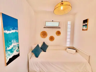 a bedroom with a white bed with two pillows at Casa das Amoreiras by YMR in Arco da Calheta