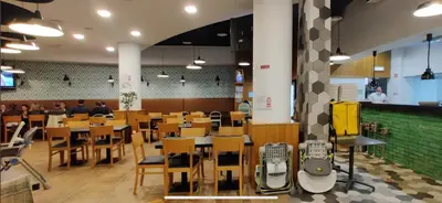 a restaurant with wooden tables and chairs and a cafeteria at Forum Ocean View Apartment 2 in Funchal