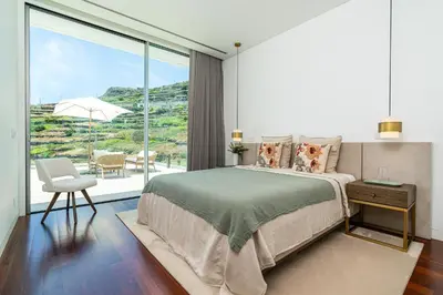 a bedroom with a bed and a large window at Refúgio na Escarpa Luxury Villa in Quinta Grande