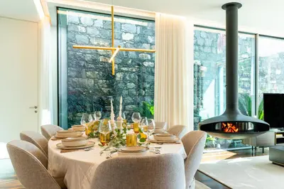 a dining room with a table with chairs and a fireplace at Refúgio na Escarpa Luxury Villa in Quinta Grande