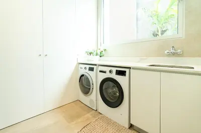 a white laundry room with a washer and dryer at Refúgio na Escarpa Luxury Villa in Quinta Grande