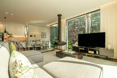 a living room with a television and a dining room at Refúgio na Escarpa Luxury Villa in Quinta Grande