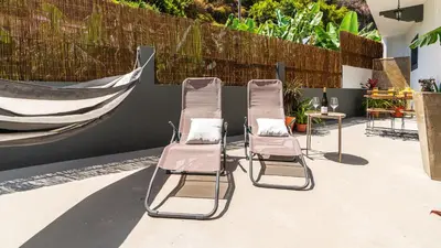 three chairs and a table on a patio at Modern Tropical Hideaway by LovelyStay in Ponta do Sol