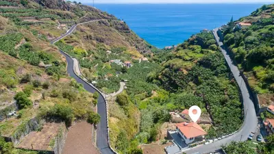 an aerial view of a mountain with a road and the ocean at Modern Tropical Hideaway by LovelyStay in Ponta do Sol
