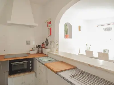a kitchen with white cabinets and a black microwave at Fazenda de Quinta de Lagos in Lagos