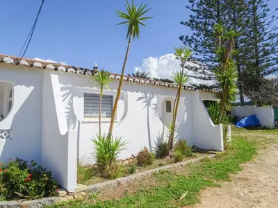 a white house with palm trees in front of it at Fazenda de Quinta de Lagos in Lagos