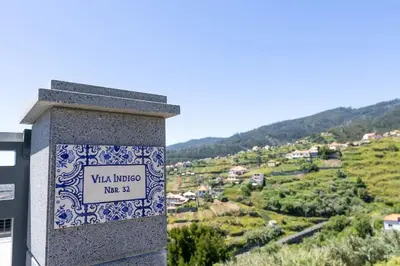 a stone pillar with a sign that reads vila hudzu me at Vila Indigo in Arco da Calheta