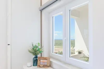 a window with a view of the ocean at Bela Vista_Cozy Apt With Sea View in Praia da Arrifana