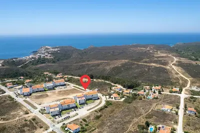 an aerial view of a village on a hill with a red marker at Bela Vista_Cozy Apt With Sea View in Praia da Arrifana
