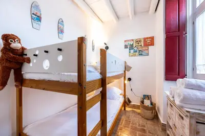 a bedroom with two bunk beds and a monkey at Casa dos Cantoneiros in Aljezur