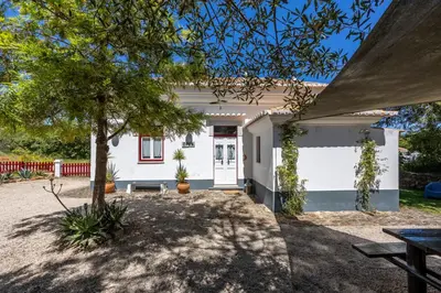 a white house with a tree in front of it at Casa dos Cantoneiros in Aljezur