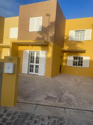 a yellow house with white windows and a driveway at Moradia Vitória in Porto Santo