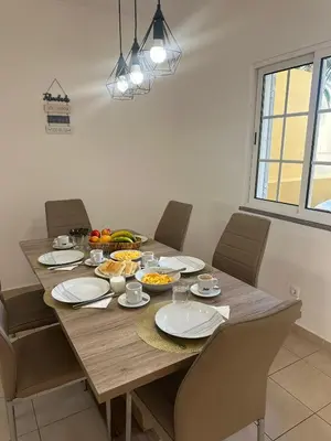 a wooden table with plates and bowls of food on it at Moradia Vitória in Porto Santo