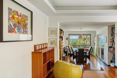 a dining room and living room with a table and chairs at Bela Vigia in Jardim do Mar