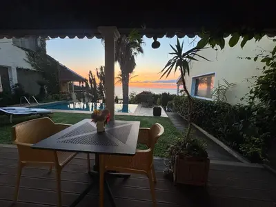 a table and chairs on a patio with a view of the ocean at Bela Vigia in Jardim do Mar