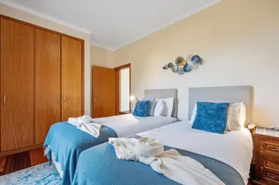 two beds in a bedroom with blue and white sheets at Casa D Agostinha by Homie in Canhas