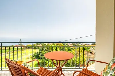 a balcony with a table and chairs and a view of the ocean at Casa D Agostinha by Homie in Canhas