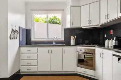a kitchen with white cabinets and a window at Casa D Agostinha by Homie in Canhas