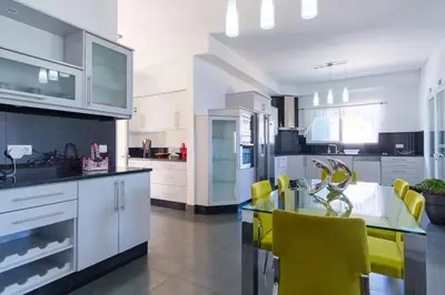 a kitchen with a glass table and yellow chairs at GuestReady - Spacious stay with sea views in Caniço