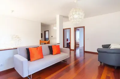 a living room with a couch and a chandelier at GuestReady - Spacious stay with sea views in Caniço