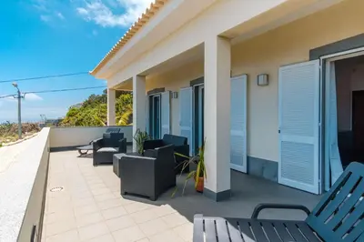 a patio with chairs and tables on a house at GuestReady - Spacious stay with sea views in Caniço
