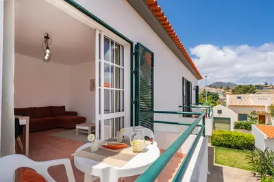 a room with a balcony with a table and a couch at Abelisa by An Island Apart in Porto Santo