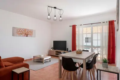 a living room with a couch and a table with chairs at Abelisa by An Island Apart in Porto Santo