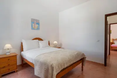 a bedroom with a bed and two lamps and a mirror at Abelisa by An Island Apart in Porto Santo