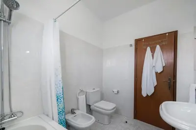 a white bathroom with a toilet and a sink at Abelisa by An Island Apart in Porto Santo
