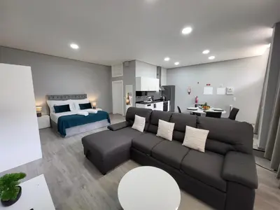 a living room with a couch and a bedroom at Lovers Caniço Center in Caniço