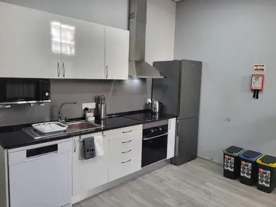 a kitchen with white cabinets and a stainless steel refrigerator at Lovers Caniço Center in Caniço