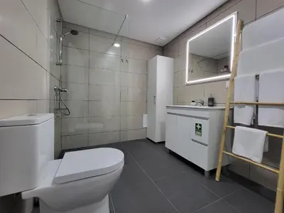 a bathroom with a toilet and a sink and a mirror at Lovers Caniço Center in Caniço