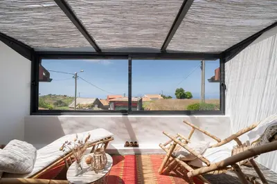a room with two chairs and a large window at Casa da Raposeira by An Island Apart in Calheta