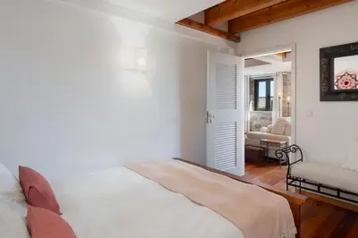 a white bedroom with a bed and a chair at Casa da Raposeira by An Island Apart in Calheta