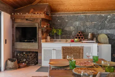 a kitchen with a table with pizzas on it at Casa da Raposeira by An Island Apart in Calheta