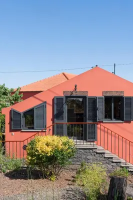 a orange house with black shutters and stairs at Casa da Raposeira by An Island Apart in Calheta