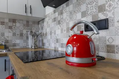 a red tea kettle is sitting on a kitchen counter at Refúgio do Cabo in Sagres