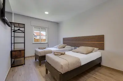 a bedroom with two beds and a window at Refúgio do Cabo in Sagres