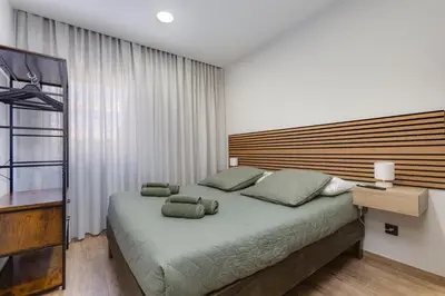 a bedroom with a large bed with a wooden headboard at Refúgio do Cabo in Sagres