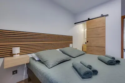 a bedroom with a large bed with a wooden headboard at Refúgio do Cabo in Sagres