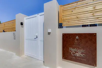 a white door with a sign on the side of a building at Refúgio do Cabo in Sagres