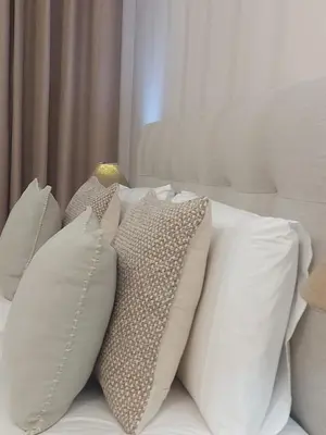 a pile of white pillows on a bed at Seminario Center Apartment in Funchal