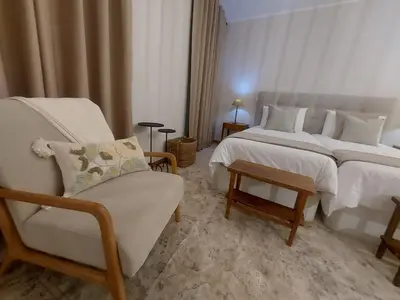 a hotel room with two beds and a chair at Seminario Center Apartment in Funchal