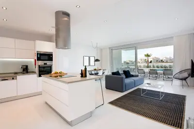 a kitchen and living room with white cabinets and a blue couch at ValMar Ocean and Pool View Apartment in Lagos