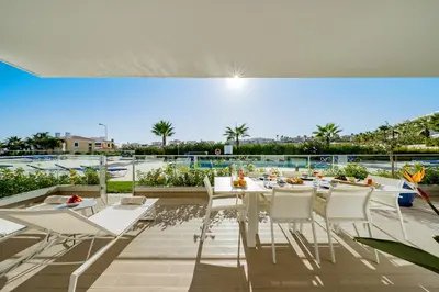 a dining room with a table and chairs on a patio at ValMar Ocean and Pool View Apartment in Lagos