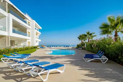 a group of lounge chairs and a swimming pool next to a building at ValMar Ocean and Pool View Apartment in Lagos